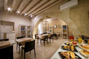 a restaurant with tables and chairs with food on them at Secret B&B in Trapani