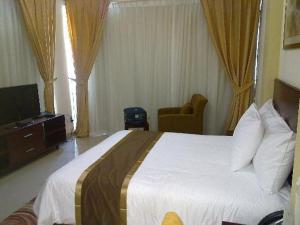 a hotel room with a bed and a television at Tumaini Guest Home in Gathundia
