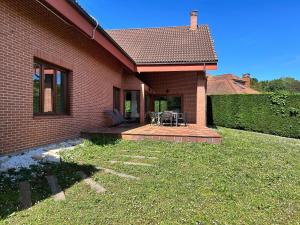 a house with a patio with a table and chairs at Ecopausa Somió - Gijón in Gijón