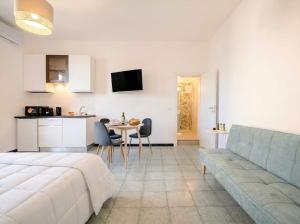 a living room with a bed and a table and chairs at SanVitoStea Seafront Apartments in San Vito