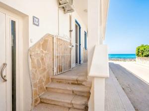 a staircase leading to the beach from a house at SanVitoStea Seafront Apartments in San Vito