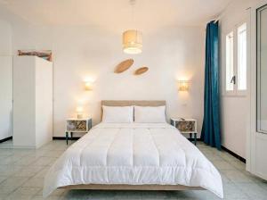 a bedroom with a large white bed and two tables at SanVitoStea Seafront Apartments in San Vito