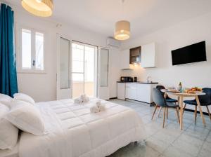 a white bedroom with a white bed and a table at SanVitoStea Seafront Apartments in San Vito