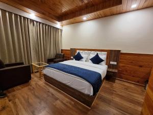 a bedroom with a bed and a chair in a room at Gaunney Valley - Tirthan Valley in Manāli