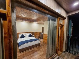 a bedroom with a large bed in a room at Gaunney Valley - Tirthan Valley in Manāli