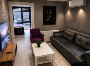 a living room with a couch and a tv at Reco Luxury Suite in Kavaklıdere +3 photos