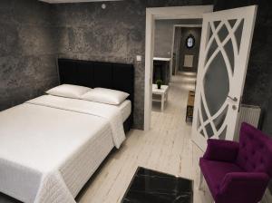 a bedroom with a bed and a purple chair at Reco Luxury Suite in Kavaklıdere