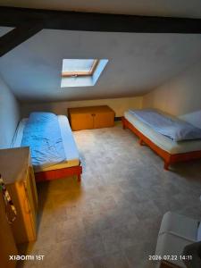 a bedroom with two beds and a skylight at Centrum Panzió VIP in Kaposvár