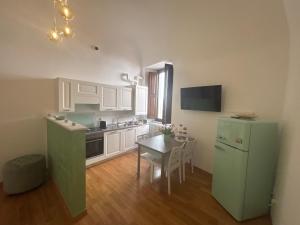 a kitchen with a green refrigerator and a table at La Dimora del Duomo in LʼAquila