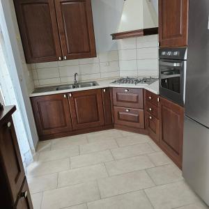a kitchen with wooden cabinets and a tile floor at B apartments LUXURY in Case Bruciate