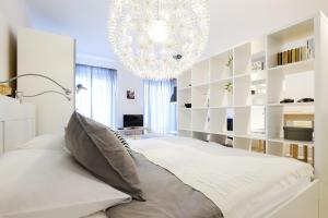 - une chambre avec un grand lit et un lustre dans l'établissement Apartments Bastova, Stela & Mia Apartments, à Bratislava