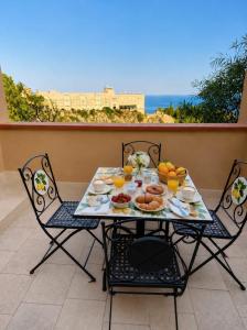 a table with plates of food on a balcony at Sarah apartment in Taormina