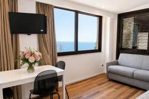 a living room with a table with a vase of flowers at Sarah apartment in Taormina