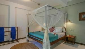 a bedroom with a bed with a canopy at Flame Tree Cottages in Nungwi +67 photos
