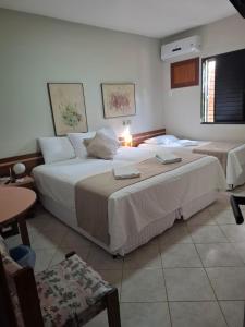 a hotel room with two beds and a table at Alpes Hotel in Venda Nova do Imigrante +38 photos