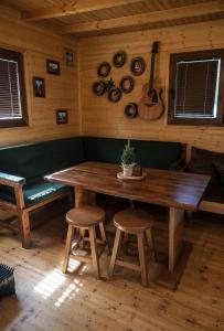 a wooden table in a room with a bench and a guitar at Scardus Lodge in Tetovo