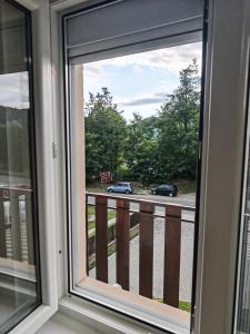 a window with a view of a street with cars at Apartman Ploče in Bajina Bašta