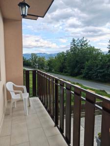 a balcony with a chair and a view of a road at Apartman Ploče in Bajina Bašta