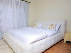 a white bed with pillows on it in a room at Nassiwa Aisha in Kampala