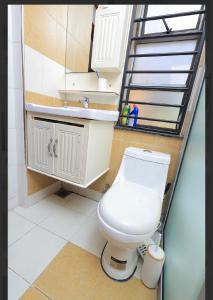 a bathroom with a white toilet and a staircase at Nassiwa Aisha in Kampala