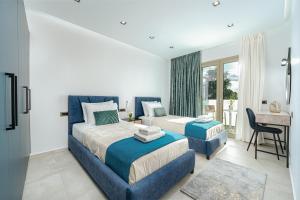 a bedroom with two beds and a desk and a table at Luminoza Villa Zakynthos in Volímai