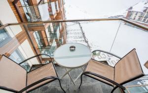 a balcony with a white table and two chairs at New Gudauri LOFT in Gudauri