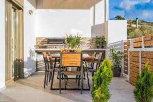 a patio with a table and chairs on a balcony at Luminoza Villa Zakynthos in Volímai