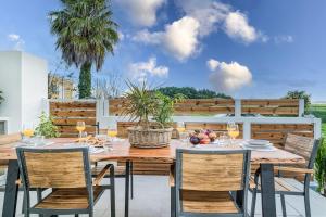 a wooden table and chairs on a patio at Luminoza Villa Zakynthos in Volímai