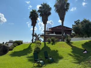 two chairs in the grass in front of a house at Villa Cocomerara Tas24 in Calimera
