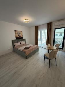 a bedroom with a bed and a table with a chair at Apartament in Ploiesti in Ploieşti
