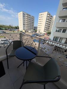 a balcony with two chairs and a table on a balcony at Apartament in Ploiesti in Ploieşti