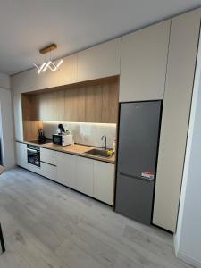 a kitchen with a refrigerator and a sink in it at Apartament in Ploiesti in Ploieşti +12 photos
