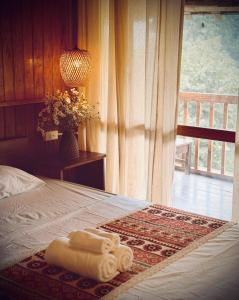 two towels sitting on top of a bed with a window at Bản Bọc Chăm Chứng in Làng Vach