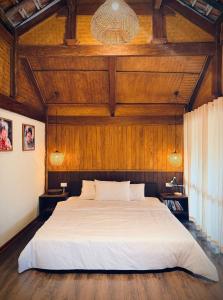 a bedroom with a large bed with a wooden ceiling at Bản Bọc Chăm Chứng in Làng Vach