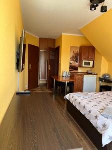 a bedroom with a bed and a kitchen with a table at Wajolet-pokoje z łazienkami in Władysławowo
