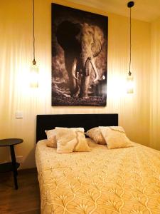a bedroom with an elephant painting on the wall at 1A Liberte in Saint-Affrique