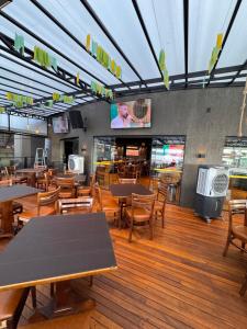 a restaurant with tables and chairs and a tv at Lindo Apart Lake Side com banheira in Brasília