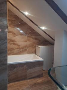 a bathroom with a bath tub under the stairs at Loft przy Starym Mieście in Jarosław