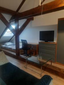 a room with a bed and a desk with a television at Loft przy Starym Mieście in Jarosław