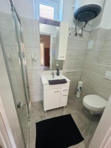 a bathroom with a toilet and a sink and a shower at Csuszka vendégház in Tiszafüred +11 photos
