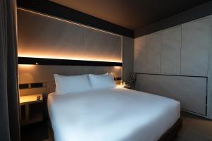 a large white bed in a hotel room with lights at Conterraneo Hotel in Marcianise