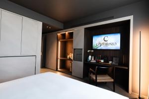 a bedroom with a bed and a tv on a wall at Conterraneo Hotel in Marcianise