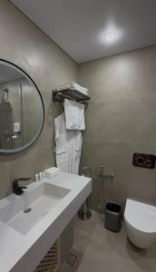 a bathroom with a sink and a toilet and a mirror at Na More Центр Семейного Отдыха in Kapchagay