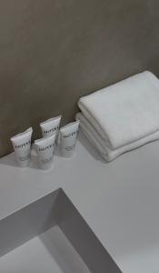 four white cups sitting on a counter with a towel at Na More Центр Семейного Отдыха in Kapchagay