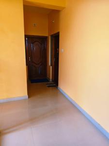 an empty room with a door and a tile floor at Sheelas stay in Guruvāyūr +1 photo