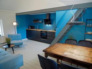 ein Wohnzimmer mit einem Tisch und einer blauen Wand in der Unterkunft De Fluessen Loft in Elahuizen