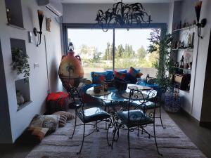 a living room with a table and chairs and a window at L'Appartement La Roche Élégance et confort in Banzart