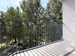 a black fence on a balcony with trees at Apartament przy Kauli in Inowrocław
