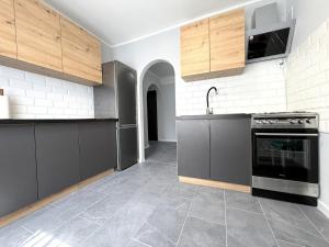 a kitchen with black and white cabinets and an oven at Apartament przy Kauli in Inowrocław +7 photos