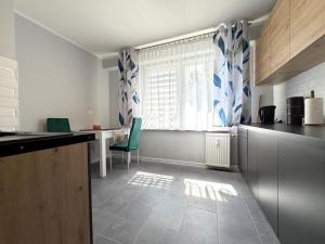 a kitchen with a window and a table and chairs at Apartament przy Kauli in Inowrocław